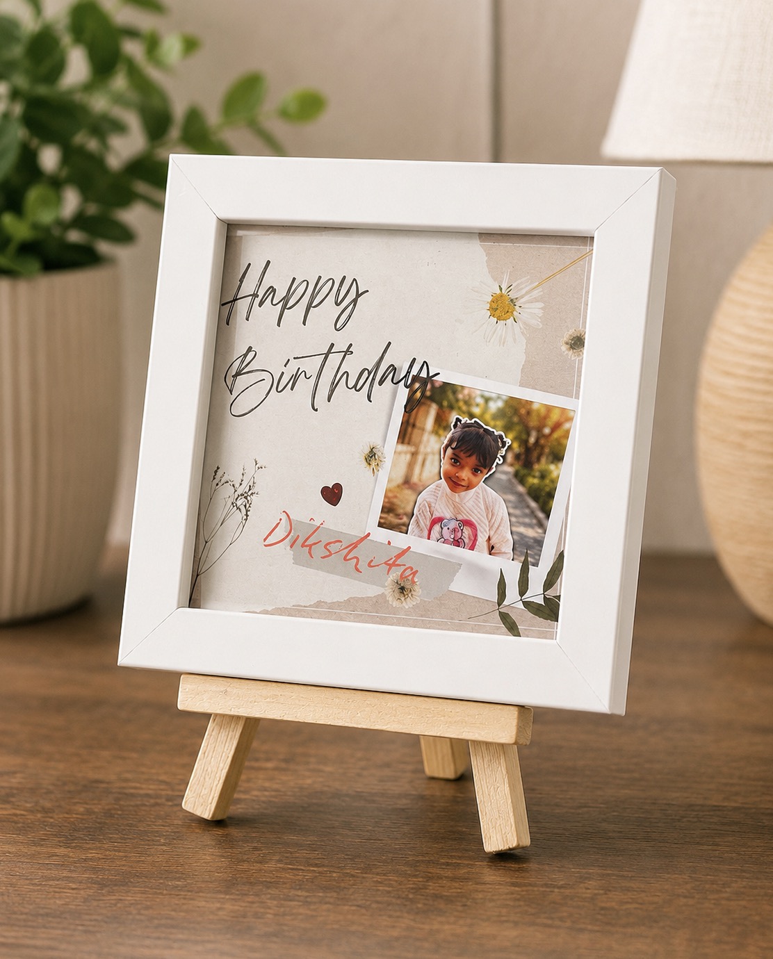 Personalized 4 by 4 inch white photo frame displayed on a wooden tri-stand